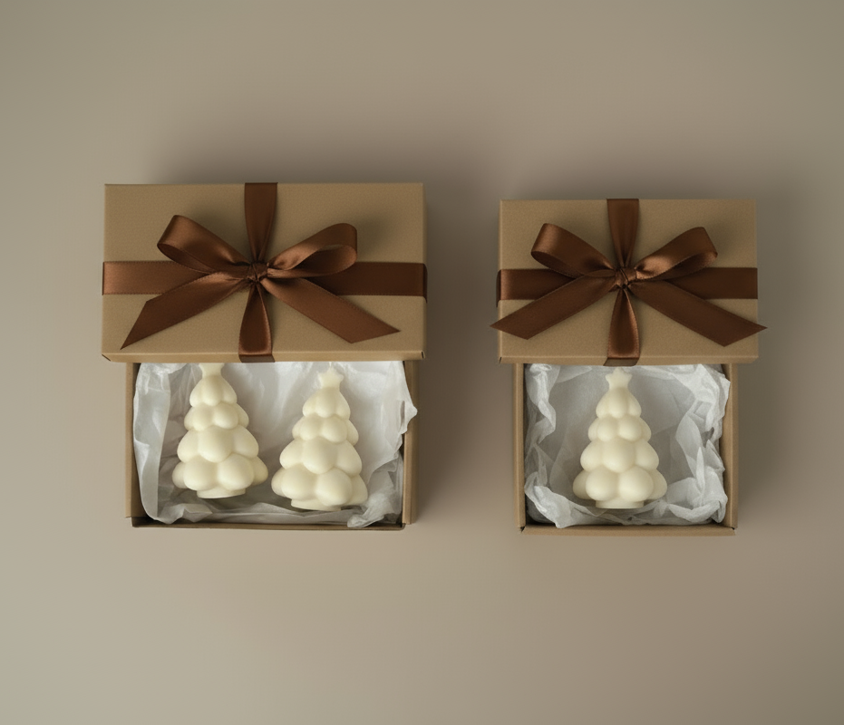 Two gift boxes with brown ribbons containing white tree-shaped candles on a beige background